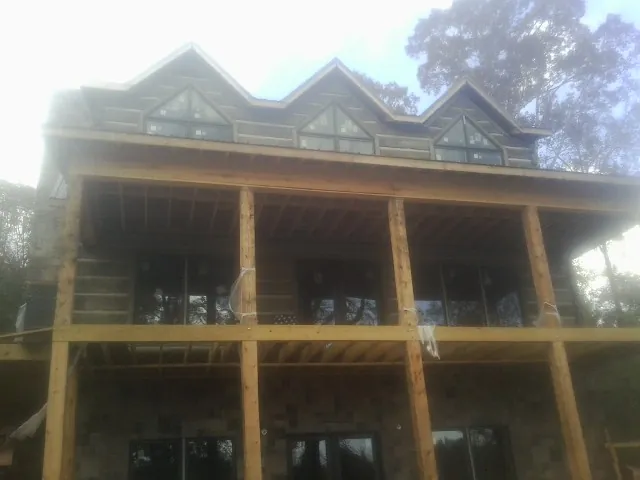 Dormers and porch framing on a large log home under construction — Roof Coating work by our crew in Frankfort